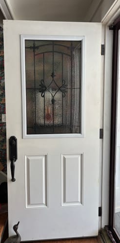 Customer's Charleston Glass and Frame Kit installed in a white door, showing the decorative wrought iron detail.