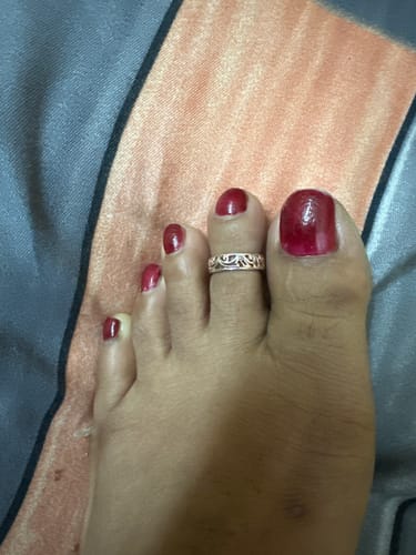 Close-up of a customer's foot wearing the intricate, silver-colored Khoobsurat Toe Ring.