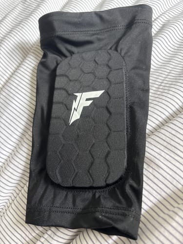 Close-up of a reviewer's black padded sleeve with a hexagonal guard lying on a bed.