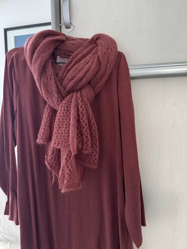Avis d'une cliente : l'écharpe Léonie rose boisé à maille ajourée, présentée sur une robe assortie.