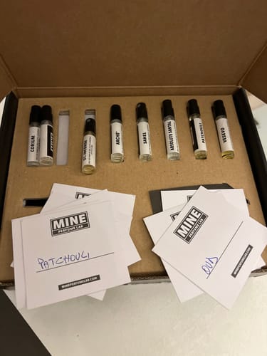 Recensore mostra il set di campioni orientali e legnosi nella sua scatola, con le fiale di profumo e le schede.