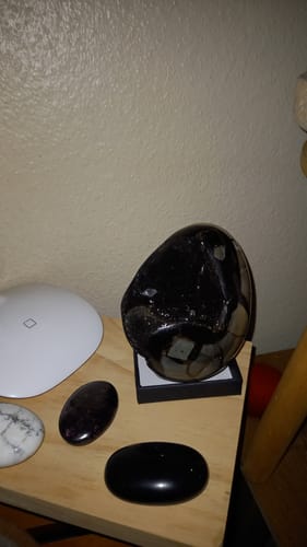 Avis d'un client : Septaria sauvage sombre et brillante posée sur un socle sur une étagère.