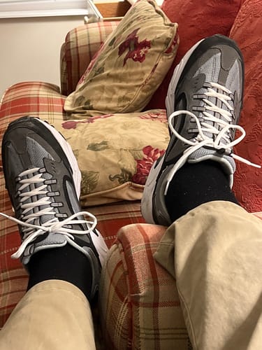 Reviewer's feet propped up on a couch, wearing black Performance Eucalyptus Compression Socks.