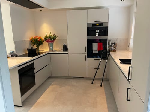 Recensent toont de zwarte Alessi Plissé waterkoker in een moderne keuken.