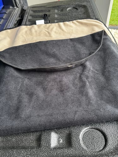 Customer's black and tan Waterproof Car Towel Seat Cover shown unfolded on a truck bed liner.