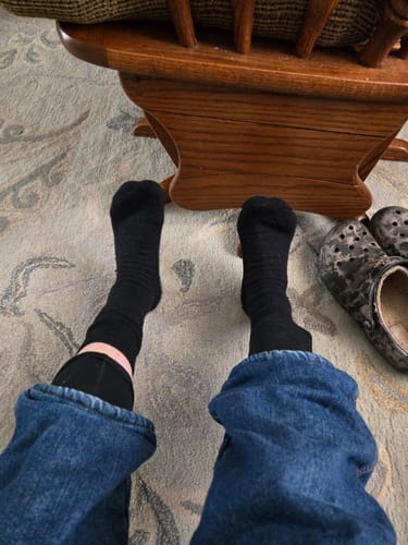 Reviewer wearing the black Men's Alpaca Socks, showing a relaxed fit around the ankle.