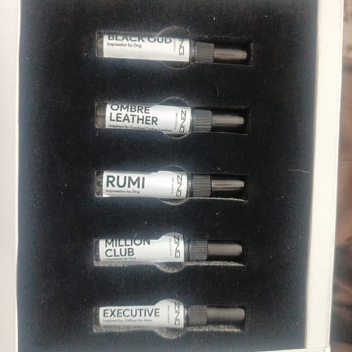Reviewer's box showing five small fragrance vials arranged neatly in a black tray.