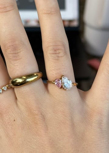 Customer's hand showing the Leesha Birthstone Ring with sparkly pink and clear pear-cut stones.