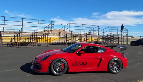 Customer's black '470' Race Number Vinyl Decals applied to the side of a red sports car at a racetrack.