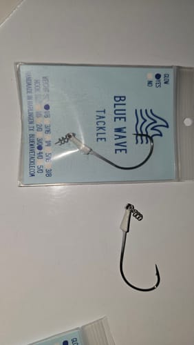 Customer displays a white Weedless Jighead from Blue Wave Tackle next to its original packaging.