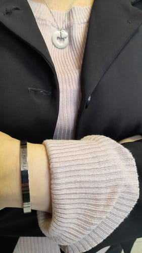 Customer wearing the Cut-Out Heart Necklace with a round pendant and small heart charm.