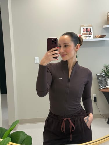 Reviewer taking a mirror selfie wearing the fitted Curve Jacket in Espresso.
