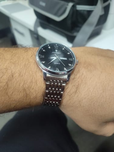 Reviewer wearing the Lucky Fours® Nassau watch, showing the black face and silver-colored metal band on their wrist.