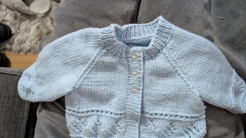 Customer's close-up of a completed light blue baby cardigan from the January Baby Boy Mystery Knitting Box.