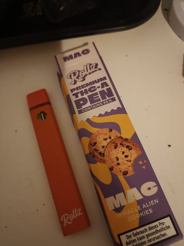 Customer's orange ROLLZ THCA Vape pen shown next to its 'Miracle Alien Cookies' packaging.