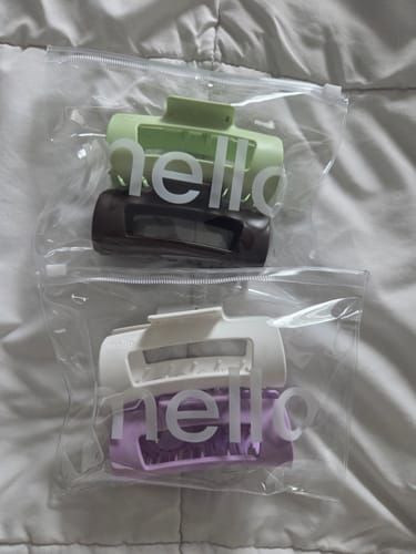 Reviewer's four cloud clips in green, brown, white, and purple, shown inside two clear packages.