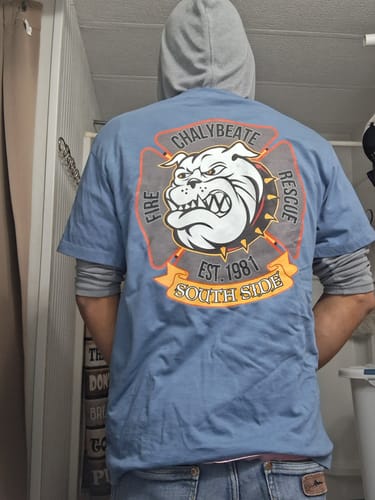Reviewer showing the back of the blue Chalybeate Fire Rescue t-shirt with a detailed bulldog graphic.