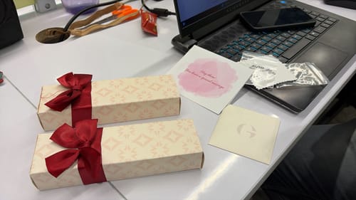 Reviewer shows the premium packaging for the Silver Leafy Kids Anklet, including two gift boxes with large red bows.