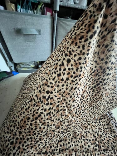 Customer's Cheetah Print Viscose Challis Fabric draped to show its soft and floaty texture in a room.