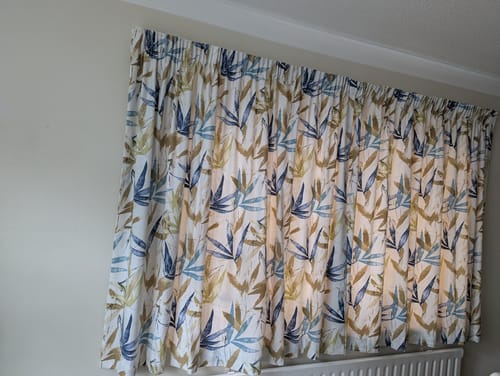 Customer's finished curtains made from the Large Leaves Cotton Canvas Fabric, hanging in a room.