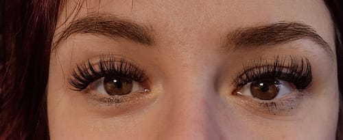 Kundin zeigt in einer Nahaufnahme ihre langen, vollen Wimpern aus dem persönlichen Starter Kit.