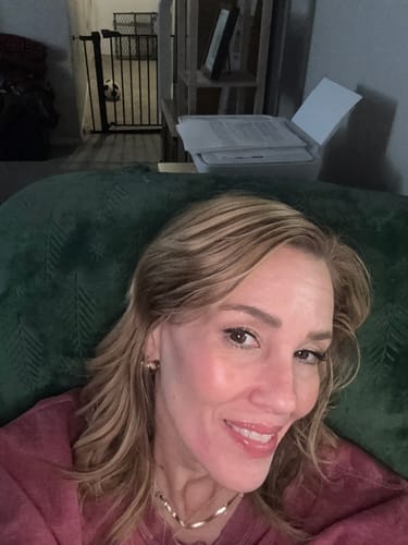 Close-up of a reviewer smiling while wearing the shiny Tara Gold Chunky Hoop Earrings.