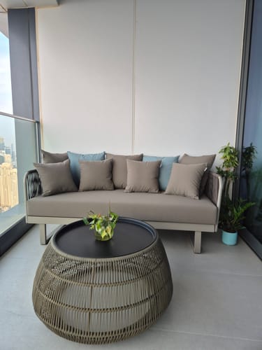 Customer's Lyon 3 Seater Outdoor Sofa in taupe, set up on a balcony with a coffee table and pillows.