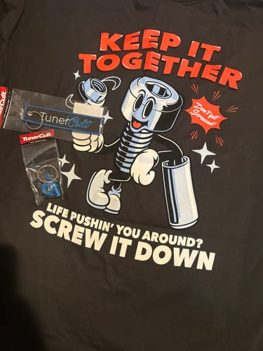 Customer's black SCREW IT TEE laid flat, showing the large cartoon screw graphic.