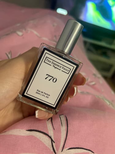 Reviewer holds a rectangular glass bottle of Inspired By Boujee Marshmallow - 770 perfume.
