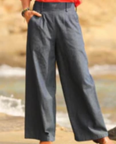 Client portant le pantalon Tom en jean brut à jambe large, avec une main dans la poche.