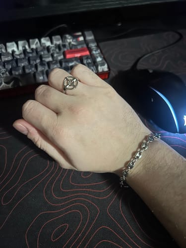 Customer's hand wearing the silver CROSSHAIR RING at a desk with a gaming keyboard and mouse.