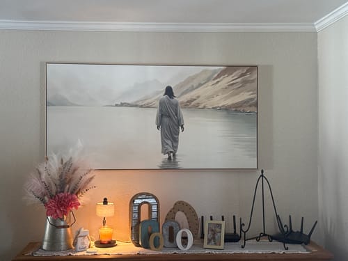 Customer's Walking on Water faith wall art hanging on a wall above a decorated console table.