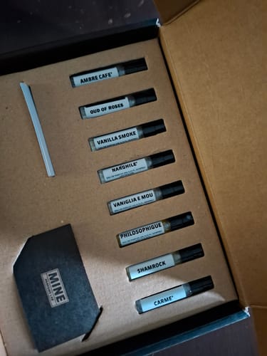 Recensore mostra il Set campioni dolci e calde nella sua scatola, con le otto fiale di profumo allineate.