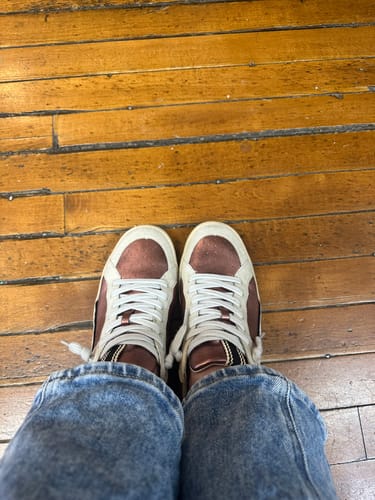 Customer's top-down view of the pair of stylish sneakers with white laces and suede accents.