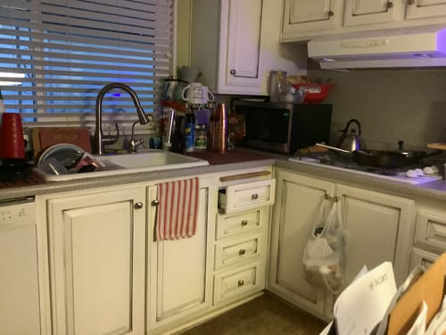 Reviewer's hand-hammered Pure Copper Water Bottle on a kitchen counter by the sink.