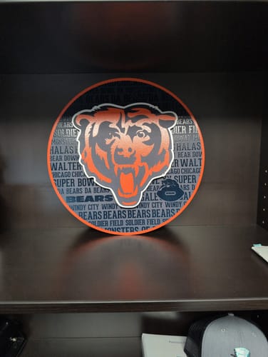 Reviewer's round Chicago Bears 3D embossed metal wall art displayed on a dark office shelf.