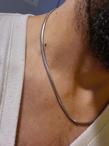 Primer plano de un cliente usando la Cadena Viper 4mm plateada en su cuello.