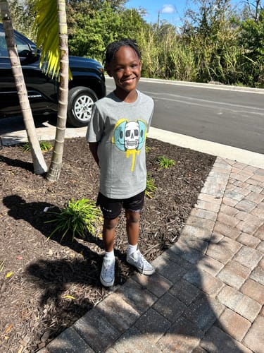 Customer standing outdoors wearing the black Psalm 56:3 'Cross' Youth Performance Shorts.