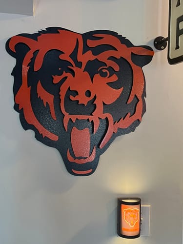 Customer's Chicago Bears 'Roaring Bear' metal wall art in orange and black, hanging on a wall in their basement bar.