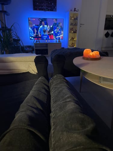 Anmelder slapper af med fødderne oppe på sofaen, iført sorte støttestrømper.