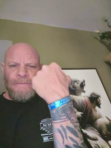 Customer holding up their arm to display a blue memorial bracelet mentioned in their review.