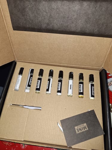 Recensore mostra il Set campioni orientali e legnose nella sua scatola aperta, con le 8 fiale di profumo allineate all'interno.