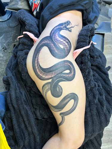 Reviewer's large, finished snake tattoo on their hip and thigh after a long session using the Painless Tattoo Numbing Cream.
