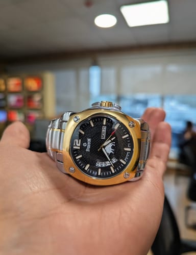 Customer holding the Bullston watch in their palm, showing its two-tone gold and silver stainless steel design.