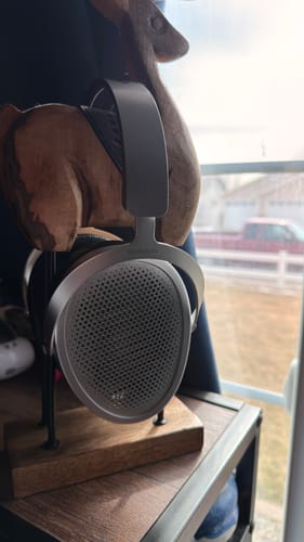 Customer's silver Hifiman Edition XV headphones resting on a wooden stand next to a window.