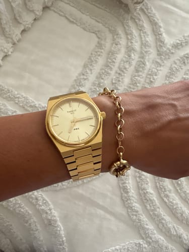 Reviewer's wrist showing the gold Chunky Rolo Bracelet worn next to a gold watch.