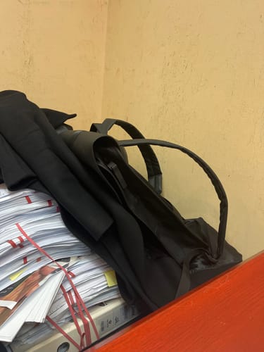 תמונת לקוח של תיק הגב העמיד למים בצבע שחור מונח על שולחן עבודה.