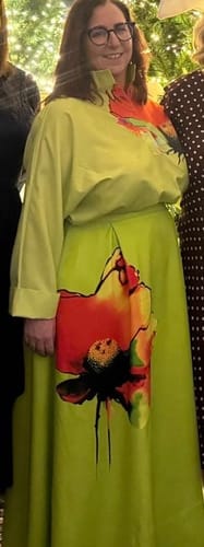 Reviewer wearing the green A-line flower print skirt with a matching long-sleeve top indoors.