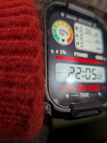 Close-up of a reviewer's Gard Pro Ultra watch on their wrist next to a red sweater.