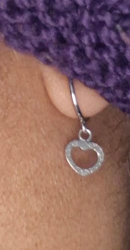 Close-up of a customer wearing the Silver Small Heart Drop Earring, showing the textured heart charm.